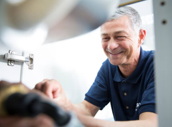 Friendly water softener installer working professionally in a UK home